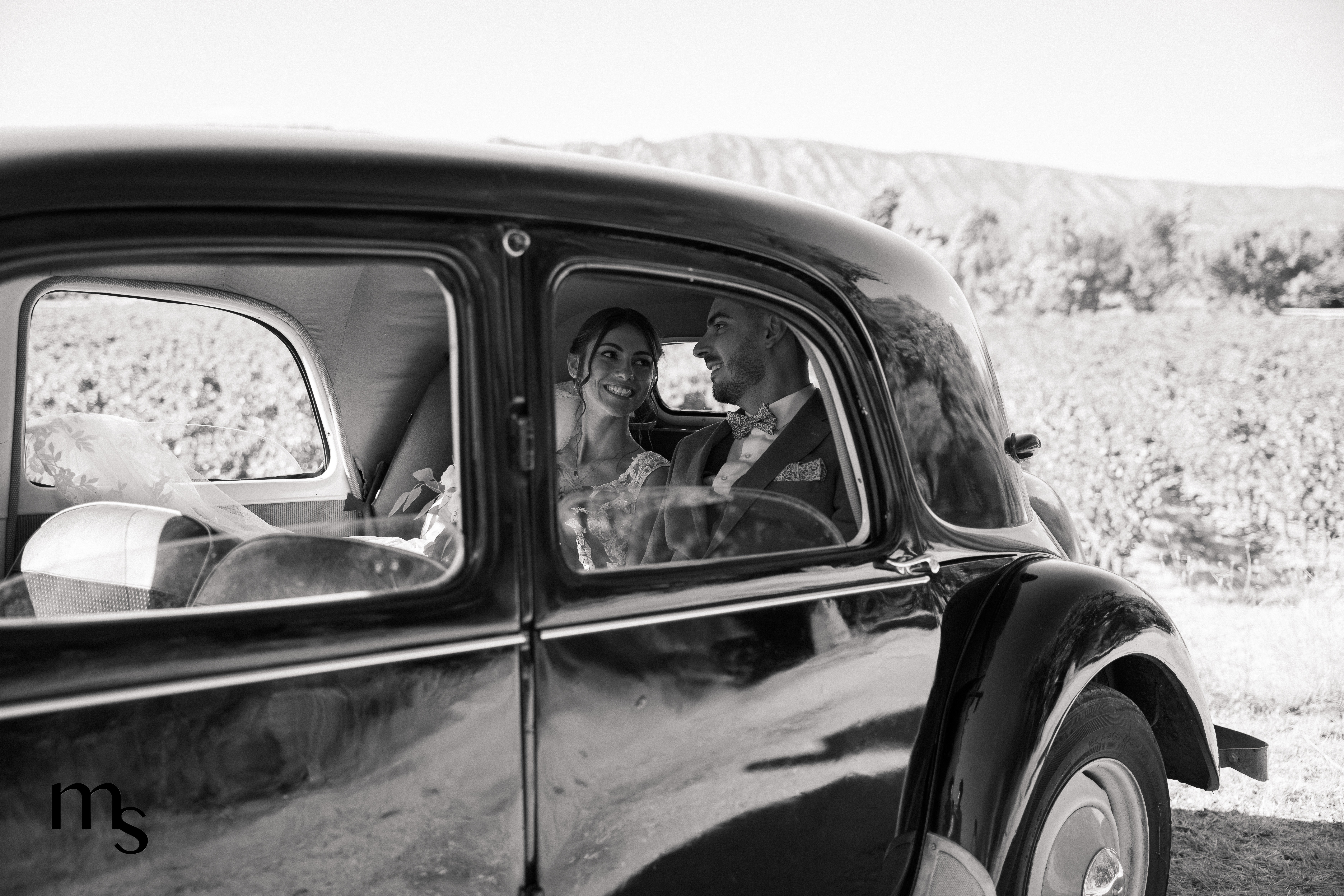 jeunes mariés dans une voiture de collection, au pied de la Sainte Victoire près d'Aix-en-Provence, vue sur les vignes