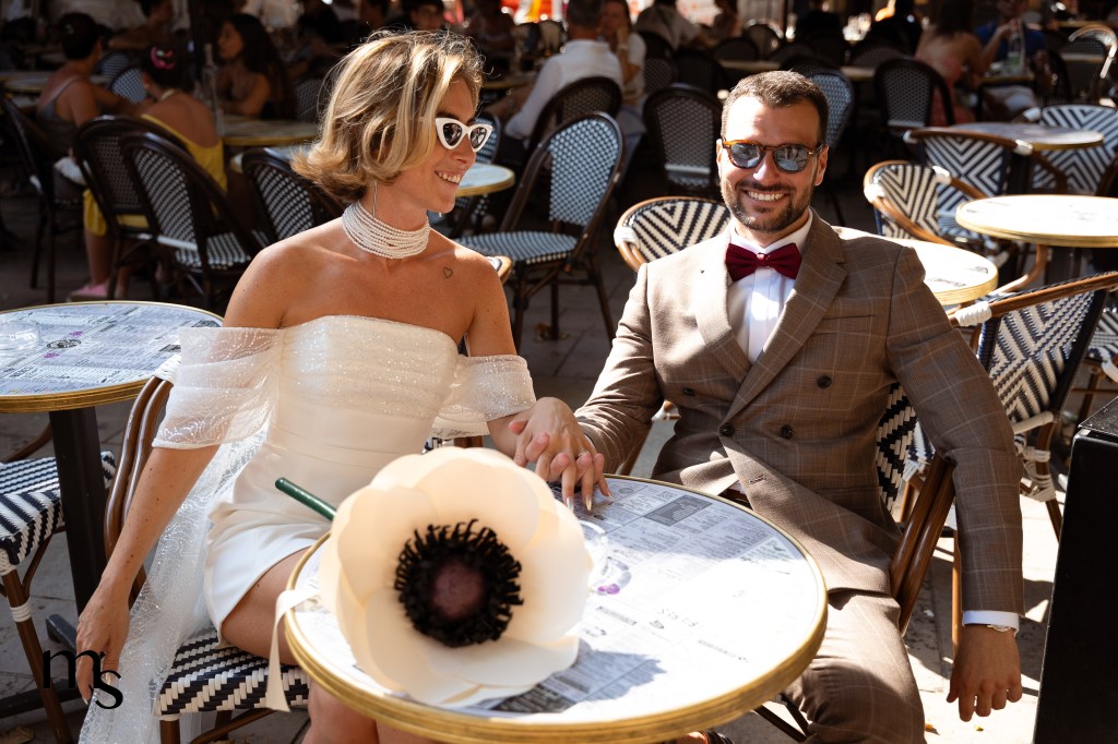 Jeunes mariés avec leurs lunettes de soleil, assis en terrasse sur une place à Aix-en-Provence