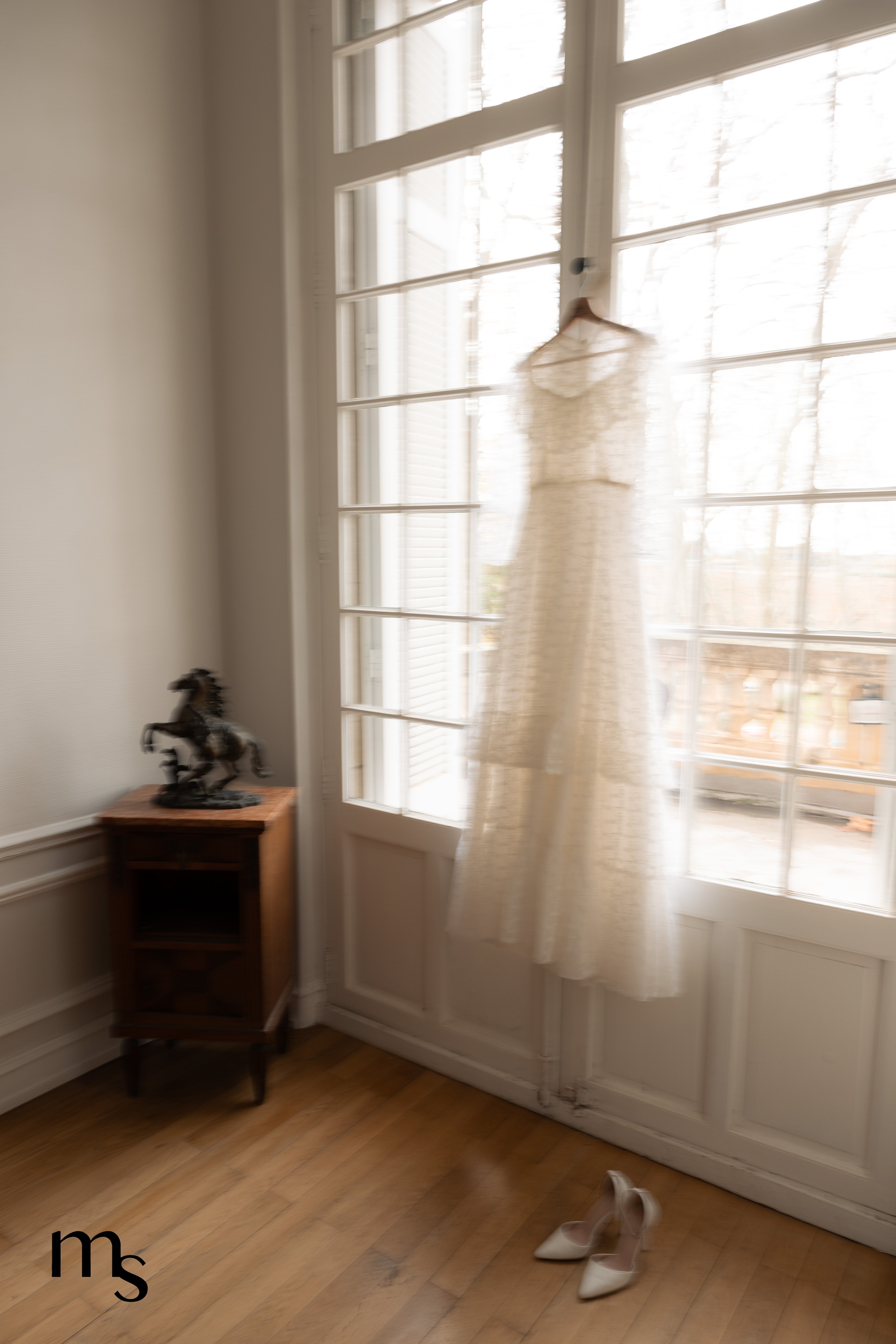 robe de mariée pendue à la fenêtre d'un chateau, photo floue en mouvement
