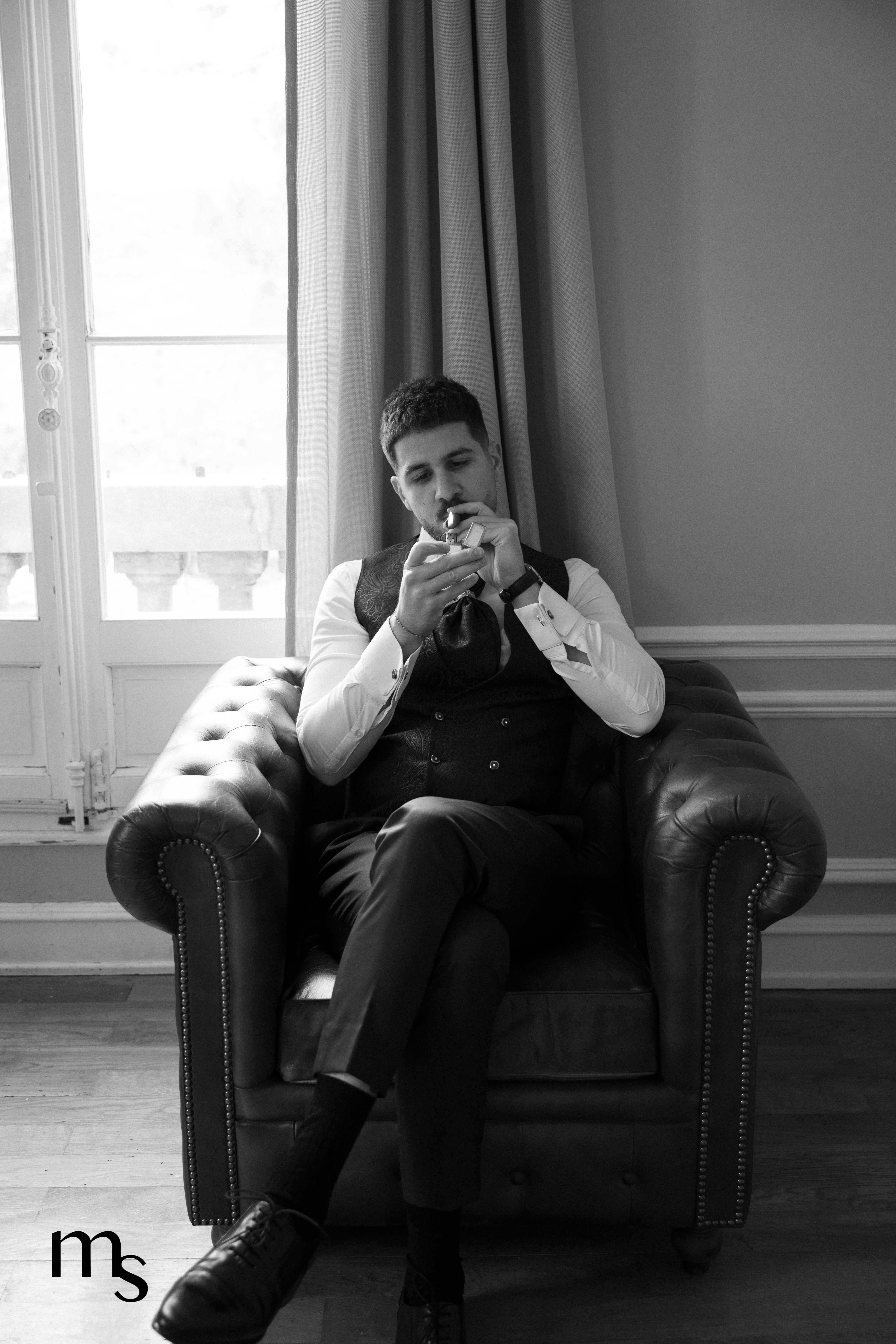 marié fumant le cigare dans un chesterfield au chateau de la Beaumetane en Provence